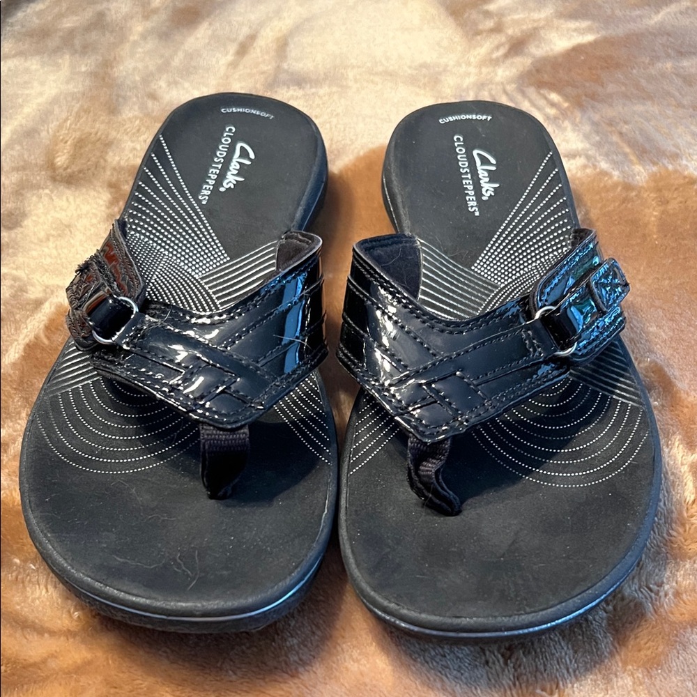 Clarks Cloud-steppers in black with patent strap.